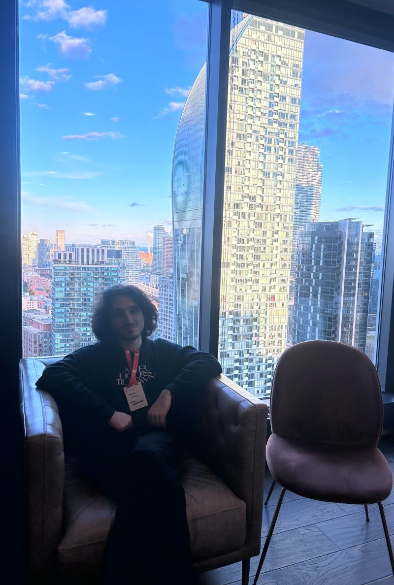 mel sitting beside a window overlooking the city skyline
